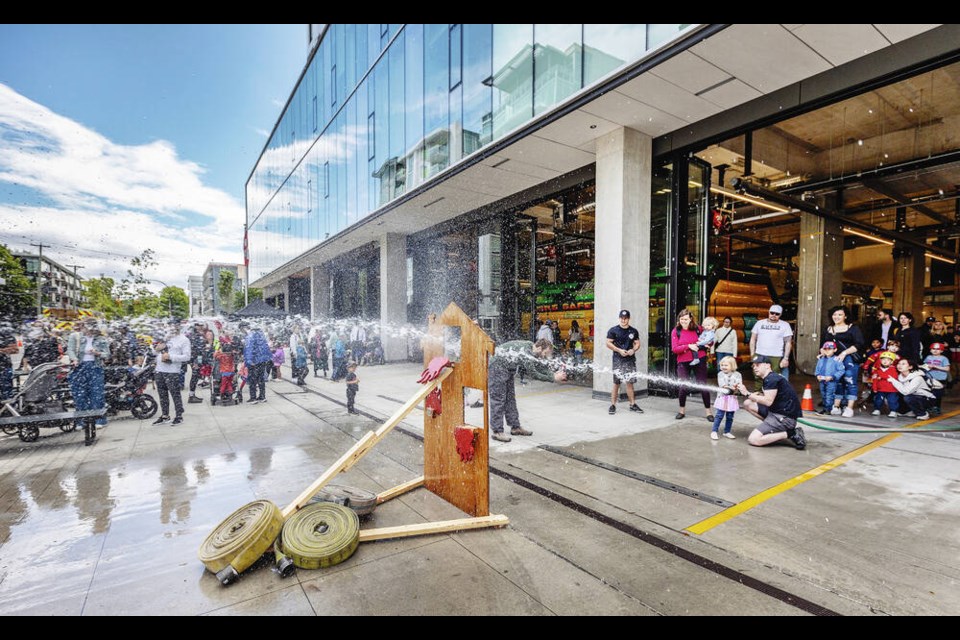 Children line up to spray a fire hose at an open house at the Victoria Fire Department headquarters at 1025 Johnson St. on Saturday. The new fire hall, part of a 12-storey complex that also has offices and housing, opened in the spring of 2023. It replaced the old headquarters fire hall on Yates Street, which was built in 1959 and was just over half the size of the new one. DARREN STONE, TIMES COLONIST 