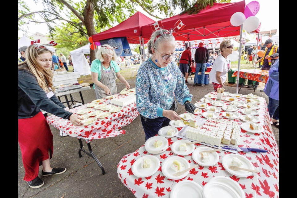 Volunteer Moira Dann cuts Canada Day cake for patrons of the James Bay Market on the Saturday. DARREN STONE, TIMES COLONIST 
