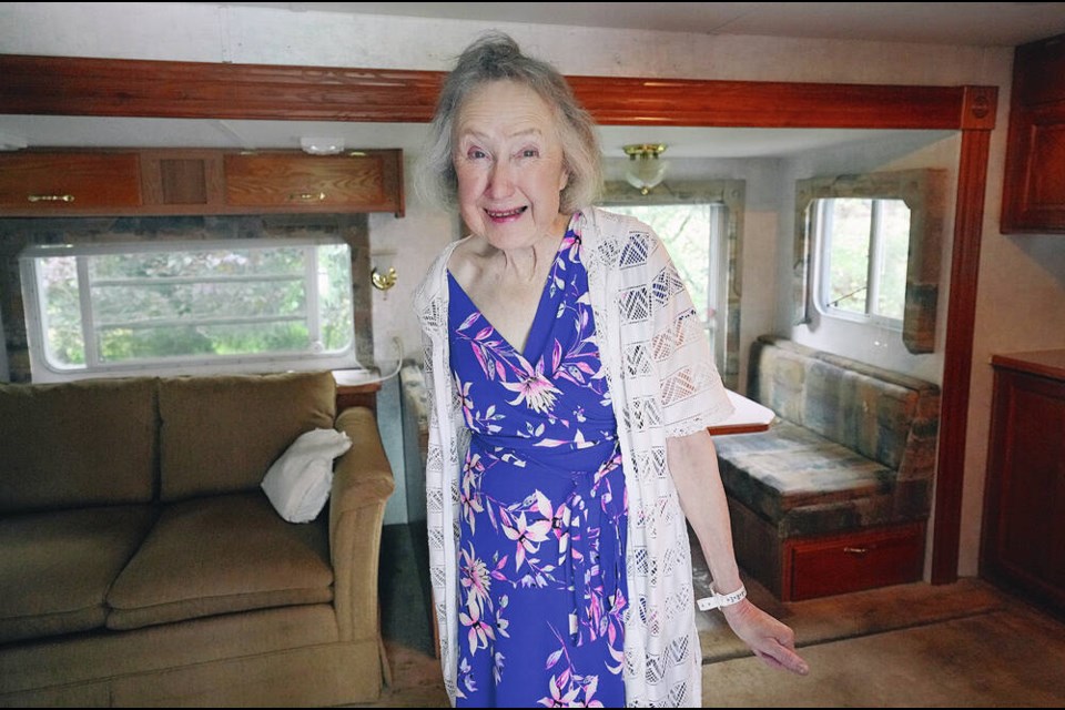 Anne Tolmie stands in a trailer, her temporary home, in front of her house on Tuesday. ADRIAN LAM, TIMES COLONIST 