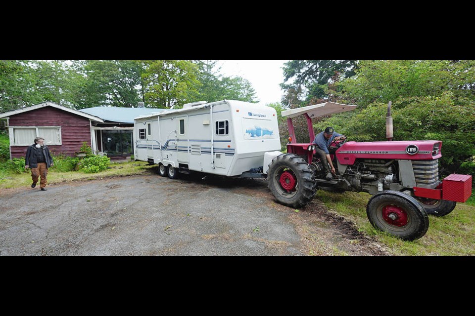 Rhys McKechnie, left, and David Chambers deliver the travel trailer to Anne Tolmie’s property. ADRIAN LAM, TIMES COLONIST 