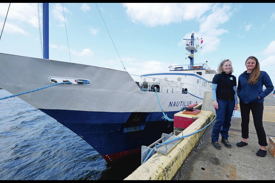 Meghan Paulson, left, and Allison Fundis in front of the Ocean Exploration Trust’s exploration vessel Nautilus at the Institute of Ocean Sciences and the Canadian Coast Guard Base Patricia Bay in North Saanich, on Tuesday. ADRIAN LAM, TIMES COLONIST