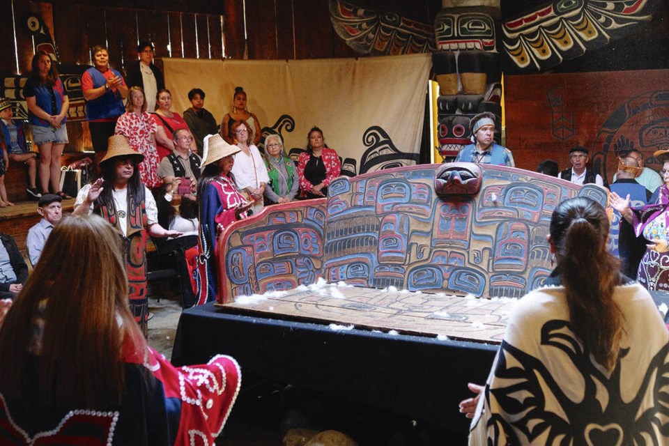 Members of the Carpenter family, dressed in regalia, bless a chief’s seat carved by Captain Richard Carpenter in the early 1900s as it is being prepared to leave Mungo Martin House at the Royal saʴý Museum, on Friday. TIMES COLONIST 