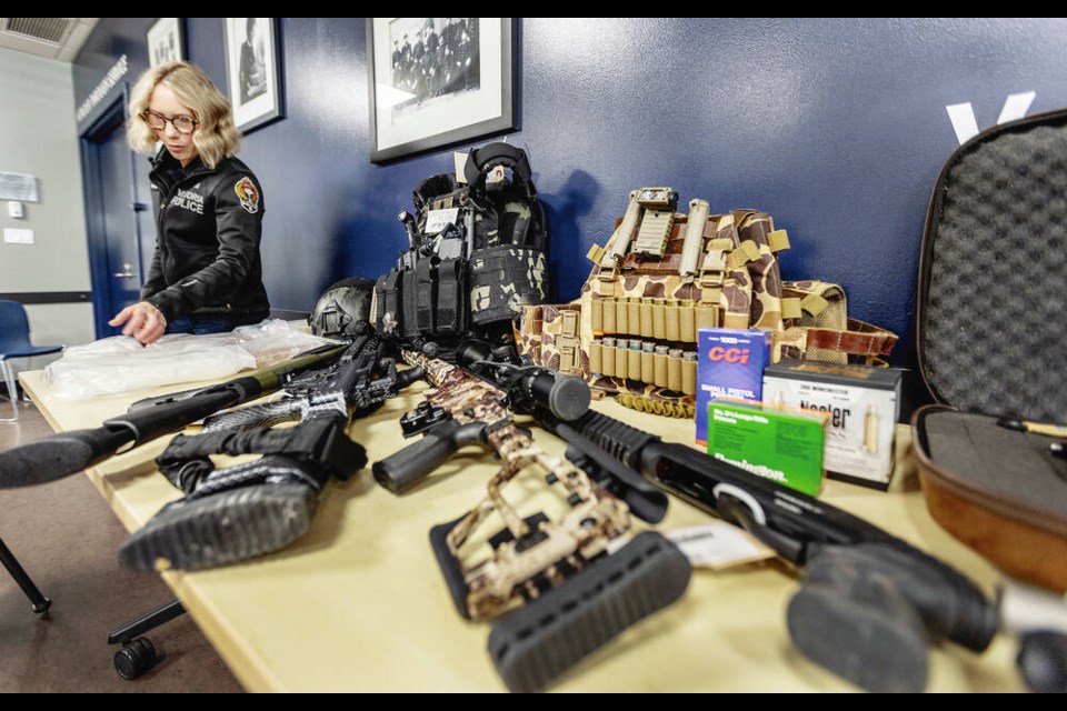 Const. Terri Healy at Victoria police headquarters with weapons and cocaine seized in a raid on a Bear Mountain home. DARREN STONE, TIMES COLONIST 