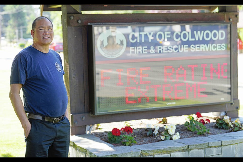 Assistant Fire Chief Greg Chow at Colwood Fire Rescue with a sign showing the extreme danger rating. ADRIAN LAM, TIMES COLONIST 