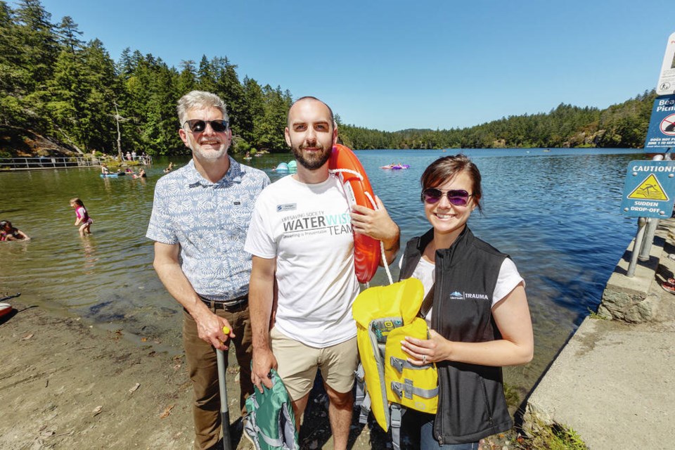 From left, Neil Arason of Island Health, Dirk Popen of Lifesaving Society BC and Yukon and Amelia Smit of Island Health were at Thetis Lake with lifejackets for National Injury Prevention Day on Friday. The health authority and Lifesaving Society plan to send out a water-safety outreach team to eight capital region water bodies this summer. DARREN STONE, TIMES COLONIST 