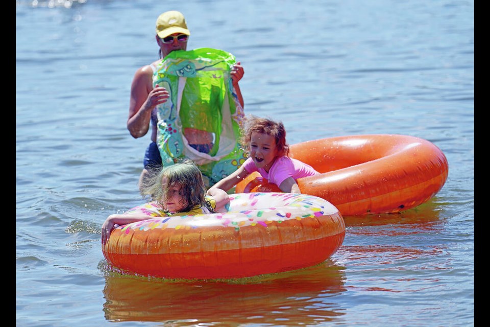 Crystal Clarke watches daughters Melody McBurnie, 5, left, and Sapphire, 6, in Elk Lake on Monday. ADRIAN LAM, TIMES COLONIST 