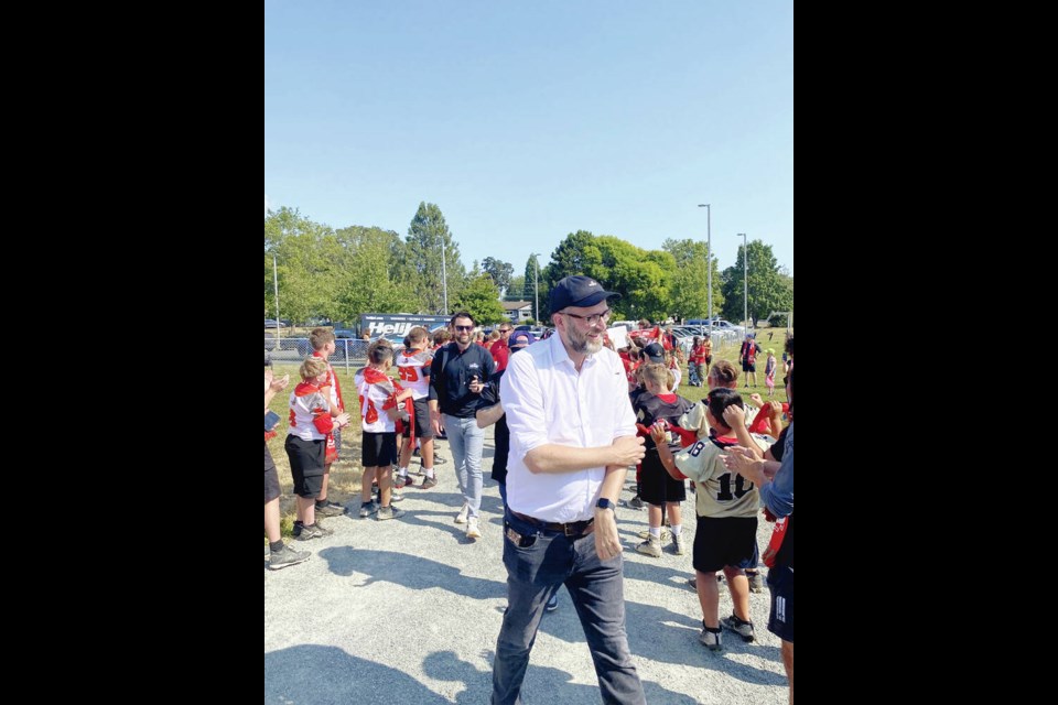 Wrexham AFC executive director Humphrey Ker leads the team contingent past welcoming young athletes at Spectrum Community School on Friday. TIMES COLONIST 