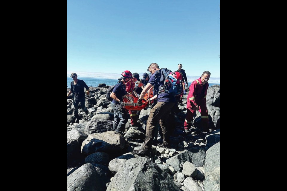 Search-and-rescue teams carry an injured hiker out of China Beach on Saturday. The injured hiker blew a whistle, which alerted other hikers, who called 911 and directed first responders to the hiker’s location. JUAN DE FUCA SEARCH AND RESCUE 