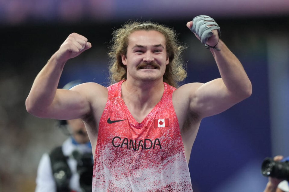 Ethan Katzberg, of Nanaimo, B.C., celebrates after winning gold in the men's hammer throw event at the 2024 Summer Olympics, Sunday, Aug. 4, 2024, in Saint-Denis, France. THE CANADIAN PRESS/Nathan Denette