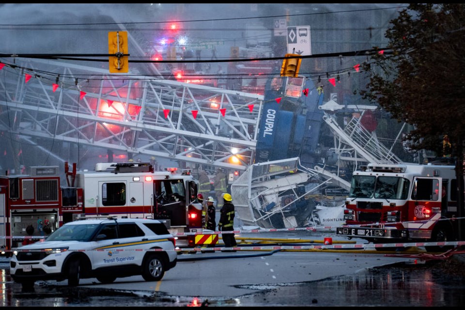 A crane lays across West 41st Avenue after a collapse as Vancouver Fire and Rescue Services spray an ongoing fire in Vancouver, on Tuesday, August 6, 2024. THE CANADIAN PRESS/Ethan Cairns 