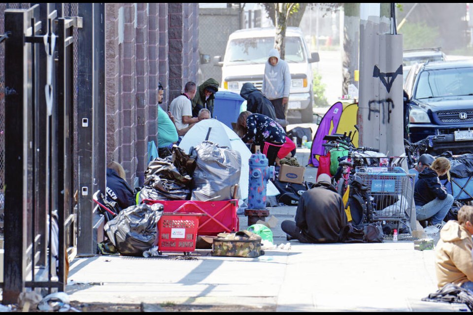 Tents and other belongings fill the sidewalk in front of Rock Bay Landing, an emergency shelter and transitional housing at 535 Ellice St. on Tuesday. Officers on special-duty overtime shifts have been patrolling Ellice and Pandora to deter criminal activities ever since a bike paramedic was assaulted by a patient on the 900-block of Pandora Avenue on July 11.	ADRIAN LAM, TIMES COLONIST 