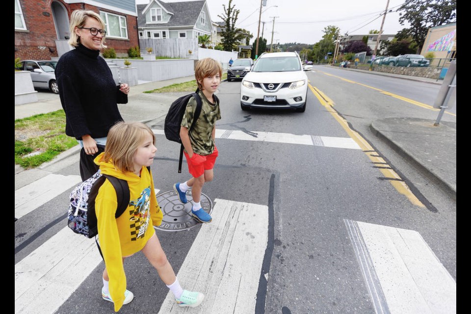 Katie McGuigan-Scott and children Charlie, 9, and Edie, 5, walk across Cook Street to George Jay Elementary School on Tuesday, the first day of school. DARREN STONE, TIMES COLONIST 