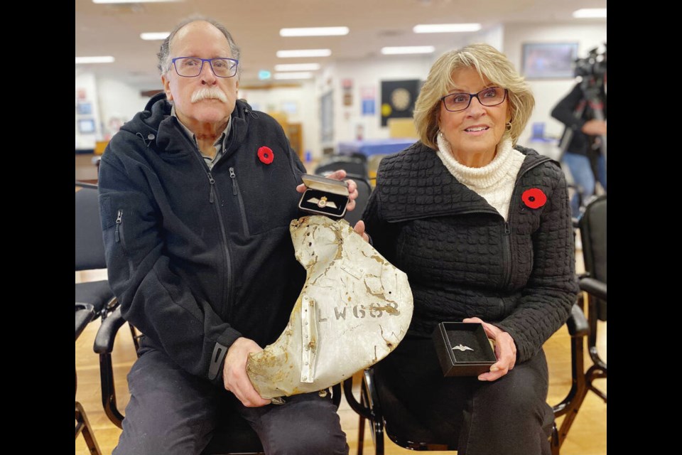 Jay Hammond of Sooke and and Maureen Thom of Ladysmith  the nephew and niece of saʴý-born bomber pilot Wilbur Bentz  with pilot’s wings fashioned from the aluminum wreckage of the Halifax bomber their uncle was piloting when it was shot down in Belgium in May 1944. Thom is holding Bentz’s original flying wings, issued when he enlisted. TIMES COLONIST 