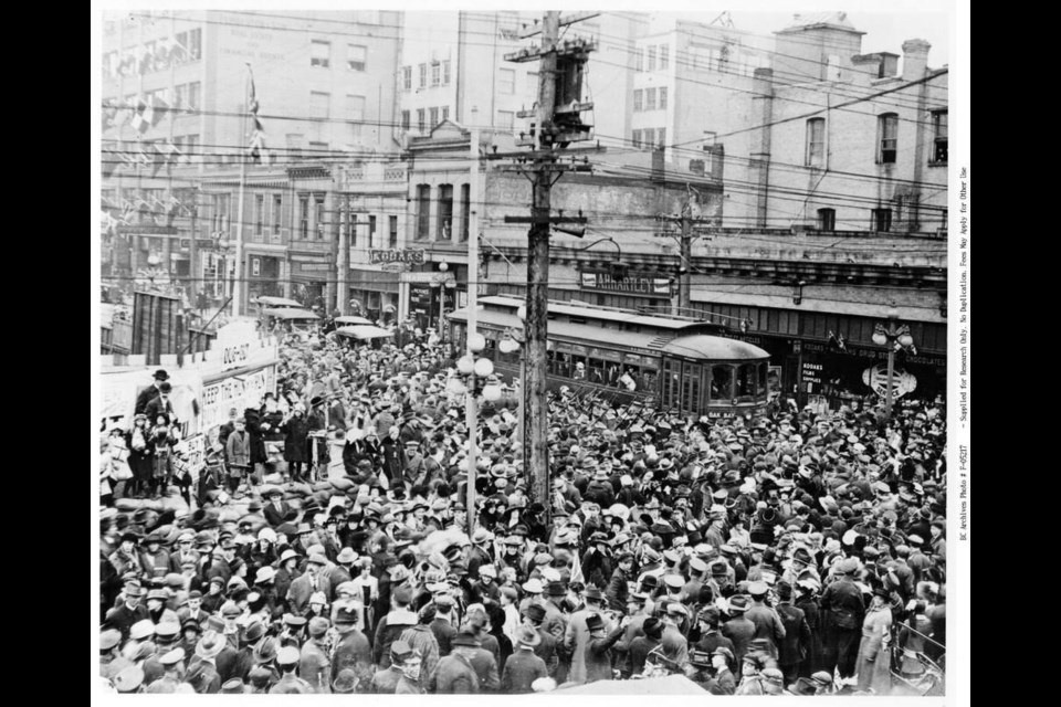 A crowd forms at the corner of Fort and Government streets on Nov. 7, 1918, following rumours of ­armistice. In October 2018, with upwards of 100 cases of  influenza already reported in Victoria, Victoria’s ­medical health officer, Dr. Arthur G. Price, closed schools, churches, libraries, theatres, colleges and dance halls for 33 days, and banned community gatherings.  IMAGE F-05217 COURTESY OF BC ARCHIVES 