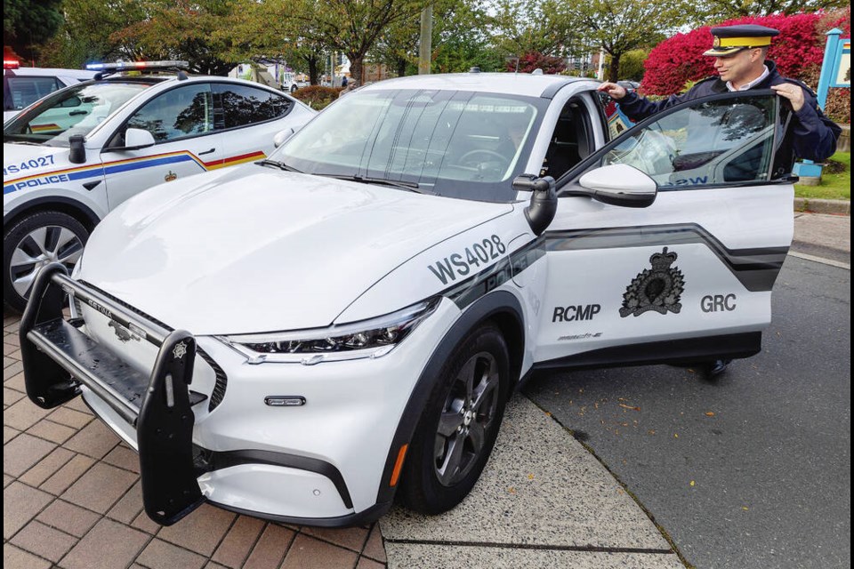 West Shore RCMP Supt. Todd Preston with the Mustang Mach-E, one of the detachment’s two new electrical vehicles. The Mustang does not have a light bar on its roof and its RCMP and police decals are in muted black and grey as part of a new “covert” look. DARREN STONE, TIMES COLONIST 