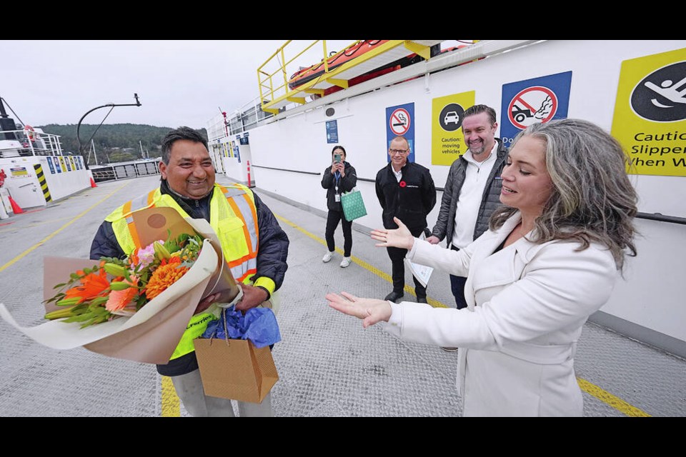 Astrid Chang of Destination Greater Victoria presents the Victoria Hospitality Award to Hardeep Parmar, a long-time deckhand of the MV Klitsa, in a special ceremony on the deck of the vessel in Brentwood Bay on Wednesday. ADRIAN LAM, TIMES COLONIST 