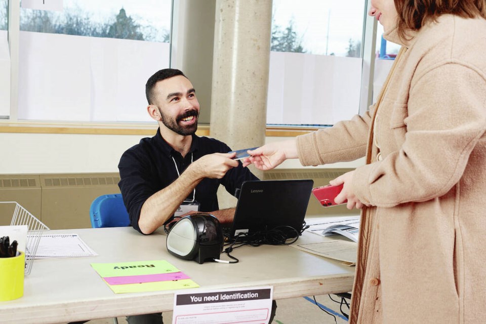 A voter checks in with an election official using a laptop rather than a paper list. VIA ELECTIONS BC 