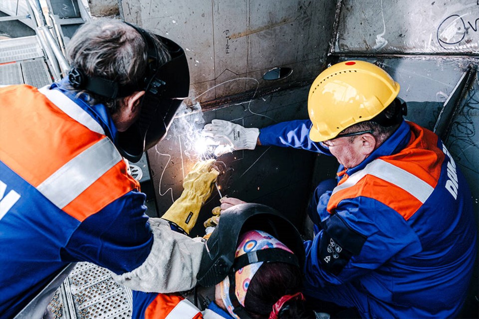 B.C. Ferries CEO Nicolas Jimenez, left, helps to weld a coin to the central frame above the keel of one of the corporation's new Island-class vessels, at Damen Shipyards Galati in Romania on Friday, Nov. 1, 2024. The coin is meant to symbolize good fortune for the ship and its future passengers. B.C. FERRIES