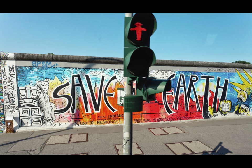 The East Side Gallery, the longest preserved stretch of the outer layer of the Berlin Wall, features artistic graffiti reading “Save the Earth,” behind an iconic red “do not walk” Ampelmann traffic signal. PHOTOS BY Dominic Arizona Bonuccelli 