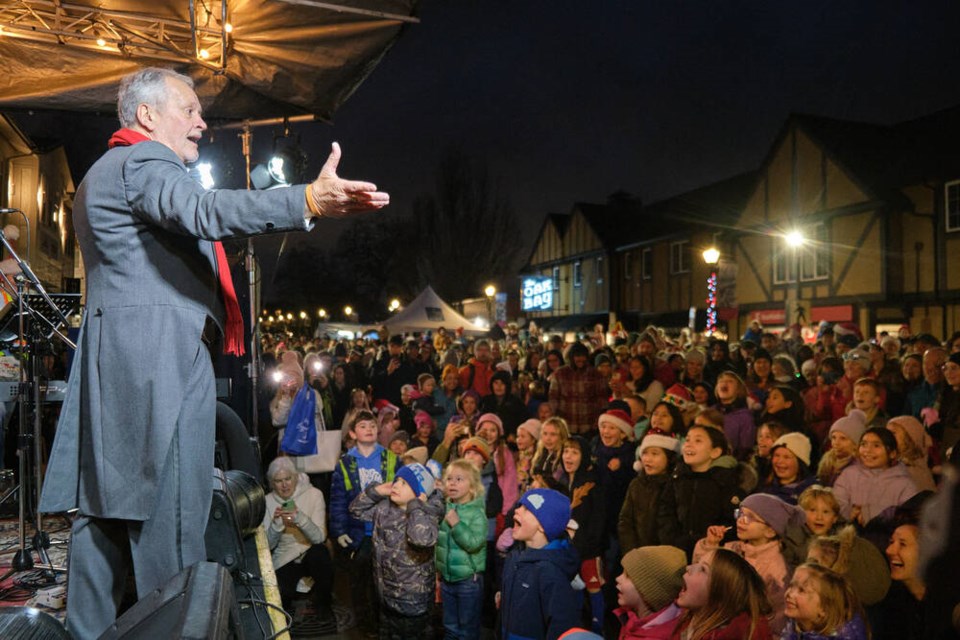 Longtime event emcee Bill Murphy-Dyson warms up the crowd on Oak Bay Avenue during the Oak Bay Christmas Festival. TIMES COLONIST