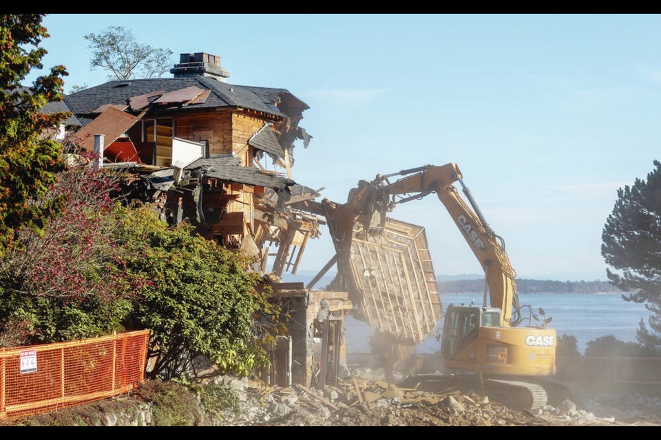 The home at 1069 Beach Dr., left, is demolished on Thursday. A home at 1101 Beach Dr., right, is also slated for the wrecking ball. A numbered company paid cash for the 
properties, with 1069 Beach Dr. going for $11 million in March and 1101 Beach Dr. selling for $9 million in December 2023, B.C. Assessment records show. DARREN STONE, TIMES COLONIST  