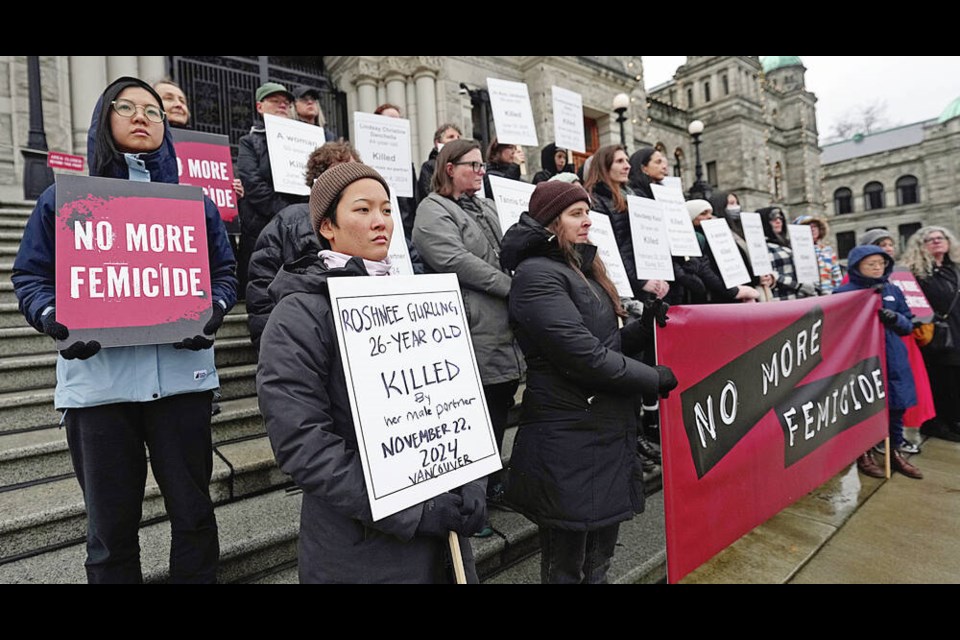 Women hold signs at the legislature on Monday with the names of 16 women who have been killed in B.C. this year by men, including two on Vancouver Island, in a silent vigil organized by Vancouver Rape Relief and Women’s Shelter. ADRIAN LAM, TIMES COLONIST 