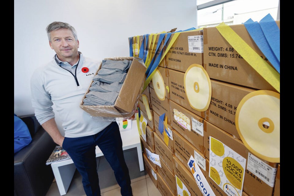 Kia Victoria owner Brad Osterman with boxes of socks being donated for the Cool Aid project. They have ­thousands of pairs already.  DARREN STONE, TIMES COLONIST 