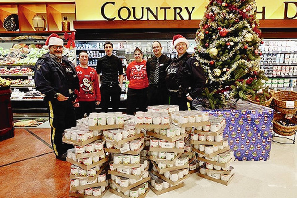 West Shore RCMP and Quality Foods staff with soup ready to donate to Langford-Colwood Embrace, an ­initiative that provides meals and support to low-income seniors on the West Shore. VIA WEST SHORE RCMP 