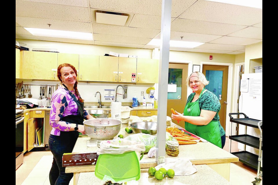 Saanich Neighbourhood Place food equity co-ordinator Tina Tulloch and program assistant Carol Pesce prepare a “Family Dinner to Go.” KUMI TANNER 