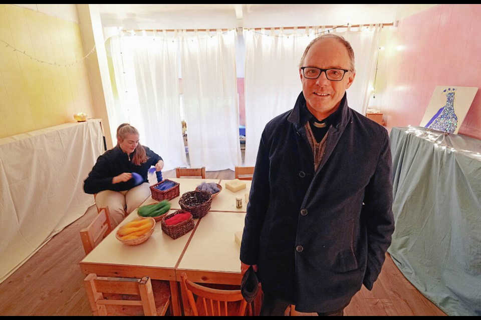 Reverand Travis O’Brian, with Anne Krayer in the background, at St. Barnabas Church. The parish is holding a “reverse craft fair,” where people, mostly children, come to make their own Christmas gifts. ADRIAN LAM, TIMES COLONIST 