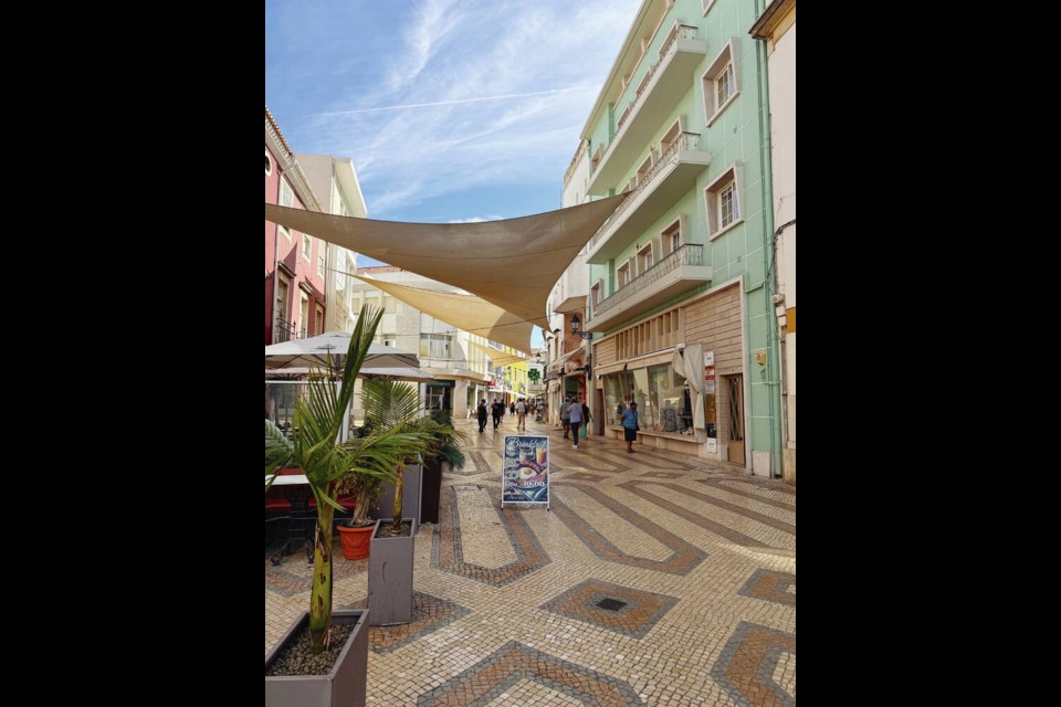 A pedestrian shopping district in downtown Faro features patterned cobblestone pathways and sails that stretch overhead between the buildings to provide shade from the blazing sun. ANGELA MANGIACASALE 