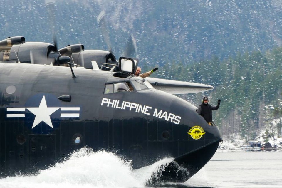 Chief pilot Peter Killin, left, and mechanic Mario Dirocco wave as the Philippine Mars leaves Sproat Lake near Port Alberni on Sunday for retirement in Arizona, in this photo taken by eight-year-old Theo Linning. VIA THEO LINNING 